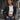 A woman wearing a black, XXL-sized cropped utility jacket, featuring a lightweight design for street style fashion. The jacket has a collar, long sleeves, and a focus on the waist area, paired with jeans, showcasing a casual and stylish outfit.