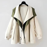 Olive green women's hooded cape jacket made from a silk blend, featuring an elegant military style with a structured collar, flowing sleeves, and a sophisticated design suitable for fashion-forward outerwear.