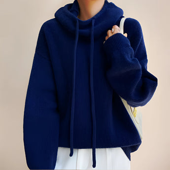
A woman wearing an oversized blue hoodie with a loose collar and long sleeves, suitable for cozy fall and winter fashion.