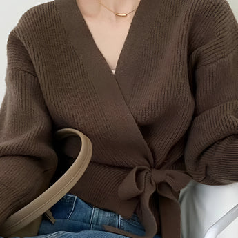 Olive green women's V-neck wrap sweater with long sleeves, styled casually with jeans, showcasing a chic autumn fashion look.