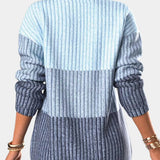 A woman wearing an ombre gradient knit sweater with blue stripes, posing with her shoulder slightly turned. The sweater is part of women's fashion knitwear, providing a casual yet chic appearance.