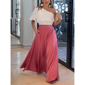 Chic summer set featuring a white one-shoulder top paired with flowy pink palazzo pants, highlighting a stylish and fashionable design.