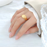 A 9mm 18K gold plated lightweight ring on a person's finger, showcasing minimalistic design, worn with a dress.