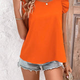 
A woman wearing an orange criss-cross back sleeveless tank top, showcasing summer fashion. The tank top is paired with white shorts, highlighting the shoulder and neck design. The woman is modeling the 2XL size.