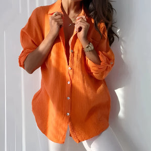 Orange linen blouse for women displayed in a casual setting, showcasing its lightweight fabric suitable for summer. The blouse is in a 2XL size, with the vibrant orange color as the focal point.