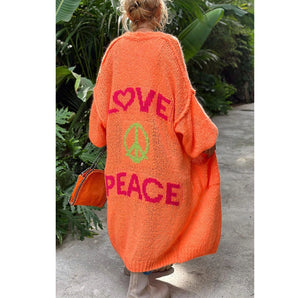 Orange oversized cardigan with peace symbol, featuring long sleeves and a relaxed fit, styled in a bohemian manner.
