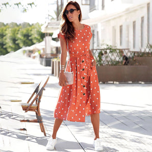 Orange polka dot sleeveless midi dress featuring a fitted waist and a flowing skirt, ideal for a casual chic summer look.