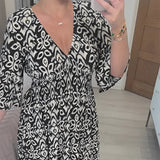 Orange and white geometric patterned V-neck summer dress with a cinched waist, shown in Nero color, size 5XL, featuring short sleeves and a stylish design.