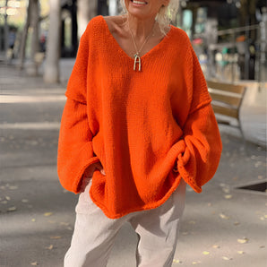 Orange oversized chunky knit sweater for women with a V-neck design, featuring long sleeves and a relaxed fit.