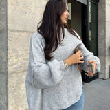 Oversized beige chunky knit turtleneck sweater with long sleeves, perfect for cozy winter fashion, worn by a standing model.