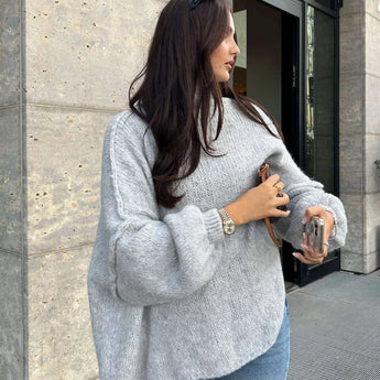 Oversized beige chunky knit turtleneck sweater with long sleeves, perfect for cozy winter fashion, worn by a standing model.