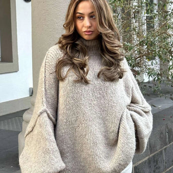 Oversized gray chunky knit turtleneck sweater with cozy long sleeves, designed as a one-size-fits-all winter fashion piece.