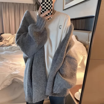 Oversized beige chunky knit women's cardigan with long sleeves and an open front, showcasing a cozy winter fashion style.