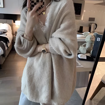 Oversized beige chunky knit women's cardigan displayed on a mannequin, featuring a cozy design with long sleeves and a prominent collar, suitable for winter fashion.
