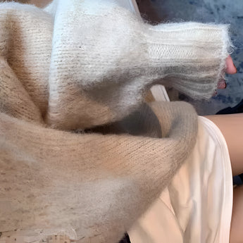 Oversized beige chunky knit women's cardigan showcased on a model, highlighting the cozy and comfortable winter fashion style. The image emphasizes the garment's long sleeves and loose fit, perfect for warmth and layering.