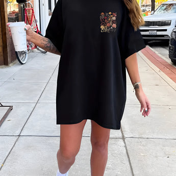 Oversized beige t-shirt dress with floral embroidery, featuring short sleeves and a relaxed fit, perfect for a summer look.