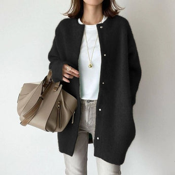 
A woman wearing an oversized black wool cardigan with long sleeves and a high collar, showcasing a winter fashion design.