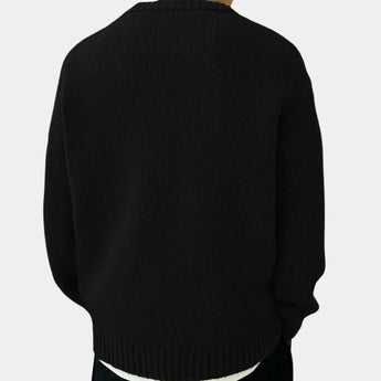 Men's oversized black ribbed knit sweater with a relaxed fit and crewneck design, featuring long sleeves.