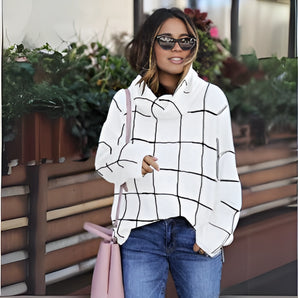 Oversized black and white checkered jacket in plus size, featuring long sleeves and a classic collar, styled with a white dress shirt. The model is standing and wearing glasses.