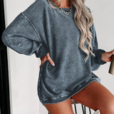 Oversized blue corduroy pullover worn by a woman with long sleeves, featuring a cozy and stylish design, showcasing her shoulder-length hairstyle and a smiling expression.