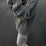 Oversized blue stripe knit sweater for women featuring long sleeves, shown on a model wearing sunglasses, highlighting autumn fashion style.