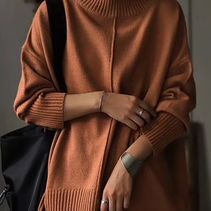 Oversized burnt orange women's crewneck sweater made of chunky knitwear with long sleeves, shown against a contrasting background.