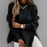 
A woman wearing an oversized chunky knit turtleneck sweater in black, showcasing a winter fashion look. The sweater features long sleeves and a loose fit, suitable for colder weather.