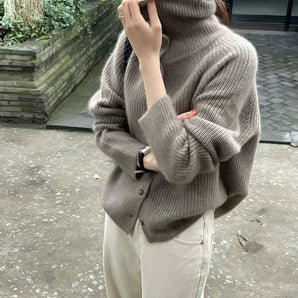 Oversized chunky knit women's brown wool turtleneck sweater featuring long sleeves and a cozy collar.