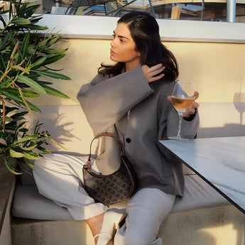 Oversized gray blazer paired with a white cropped top and matching trousers, showcasing a chic streetwear outfit with attention to fashion details like the collar and sleeves.