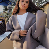 Oversized gray blazer paired with a cropped top and trousers, showcasing a chic streetwear outfit. The blazer features a relaxed fit with prominent sleeves and a notched collar, complementing the fashionable and comfortable ensemble.