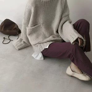 Oversized gray ribbed knit women's sweater, showcasing cozy winter fashion, featuring long sleeves and a comfortable fit.