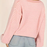 Oversized green striped knit sweater with a cozy boat neck design, worn by a person in casual jeans, showcasing the shoulders and arms.