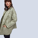 Oversized green women's quilted puffer jacket, lightweight and casual for autumn, featuring a high collar and long sleeves.