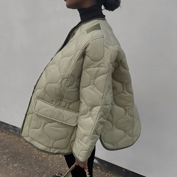 Oversized green women's quilted puffer jacket with lightweight material and casual design for autumn, featuring long sleeves and a high collar.