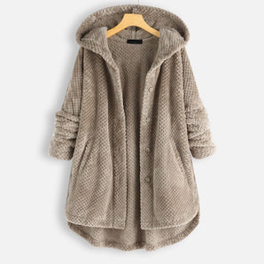 Oversized hooded knit sweater coat in chunky taupe, displayed on a clothes hanger, featuring long sleeves and a cozy, textured design suitable for winter.