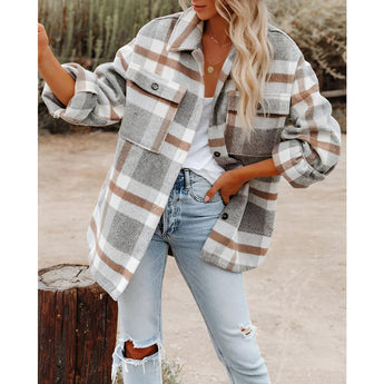 
A woman wearing an oversized plaid jacket in khaki color, paired with jeans. The jacket features a long sleeve design, suitable for autumn street style. She is wearing white shoes and sunglasses, creating a fashionable look.