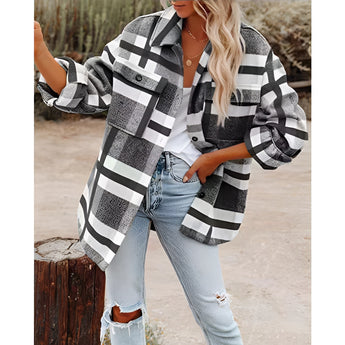 Oversized gray plaid jacket for women, featuring long sleeves and an autumn street style. The model is wearing the jacket over a casual outfit with jeans and black shoes, showcasing a fashionable look. The jacket's pattern includes a tartan design, and the model is carrying a bag.