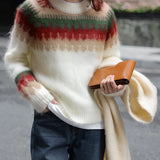 Oversized cream plaid wool scarf with fringe draped over shoulders, styled as an urban chic winter accessory.