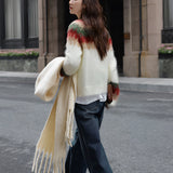 Oversized plaid wool scarf with fringe draped around a person's neck, showcasing a chic winter fashion accessory against an urban backdrop.