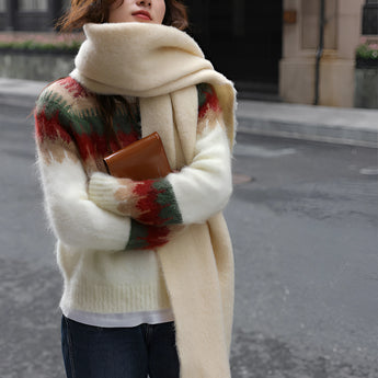 Oversized plaid wool scarf with fringe draped around a model's neck and shoulders, showcasing the urban chic winter accessory against a backdrop of the model's face and hair.