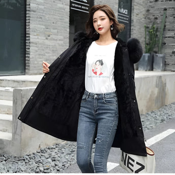 Oversized red fur hooded coat with luxurious texture, worn by a model paired with jeans and eyewear, showcasing a winter fashion look.