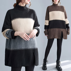 Oversized black and white striped turtleneck sweater dress in chunky knit fabric, showcasing winter fashion with long sleeves and a relaxed fit.