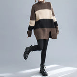 Oversized brown turtleneck striped sweater dress in chunky knit, showcasing a cozy winter fashion style, worn by a person with visible legs and partial accessories like eyewear.