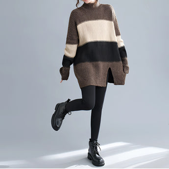 Oversized brown turtleneck striped sweater dress in chunky knit, showcasing a cozy winter fashion style, worn by a person with visible legs and partial accessories like eyewear.