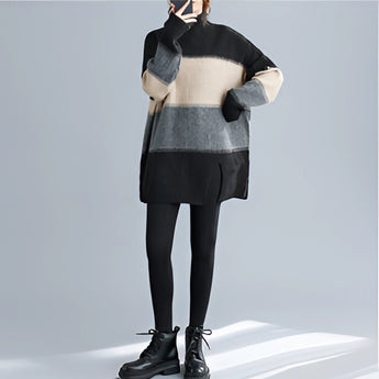 
An oversized turtleneck striped sweater dress in chunky knit, featuring a fashionable design in black. The dress has long sleeves and falls to the knee, showcasing a cozy winter style.