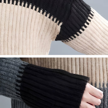 Oversized turtleneck striped sweater dress in chunky knit fabric, featuring black and white stripes and long sleeves, displayed in a well-lit setting with a hint of greenery in the background.