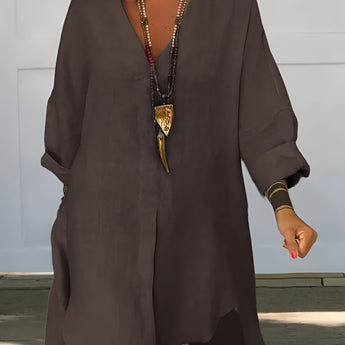 
An oversized white linen blouse with a relaxed fit, featuring a casual chic bohemian style. The blouse has a soft collar, long sleeves, and a comfortable waistline, ideal for summer wear. The model is standing, showcasing the blouse's loose and airy design.