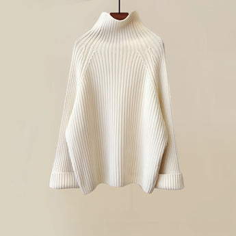 Oversized white turtleneck sweater made of cozy ribbed knit fabric, featuring long sleeves and a relaxed fit, ideal for winter wear.