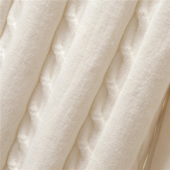 
An oversized white turtleneck sweater made from cozy ribbed knit fabric, featuring long sleeves and a relaxed fit, ideal for winter wear.