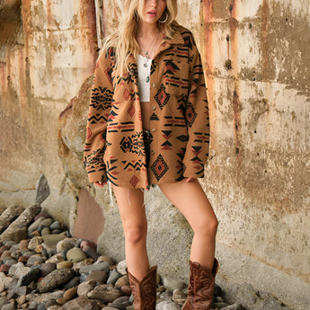 Oversized women's Aztec jacket featuring a boho tribal pattern, worn with fashionable footwear and a hat, highlighting the sleeves and overall style in a casual setting.